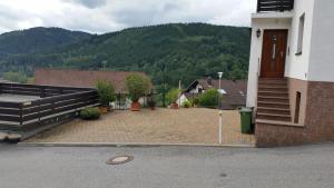 a building with a courtyard with stairs and a mountain at Ferienhaus KorsikaBlick in Unter Schönmattenwag