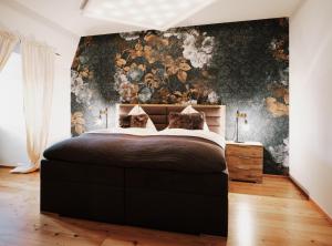 1 dormitorio con 1 cama grande y papel pintado con motivos florales en Kaiser Apartments - City Centre of Graz, en Graz