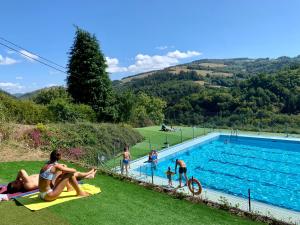 a group of people sitting around a swimming pool at A Casoa II in Santa Eulalia de Oscos