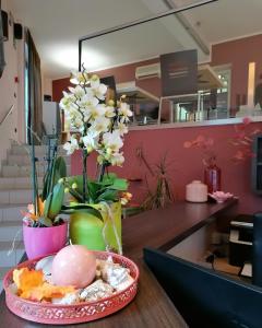 einen Tisch mit einem Teller Essen und eine Vase mit Blumen in der Unterkunft Rooms&Apartments Hotel Danci in Borghetto Santo Spirito