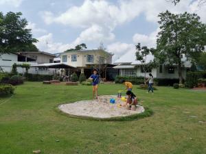大城的住宿－Baan Suan Krung Kao，一群孩子在院子里的沙箱里玩耍