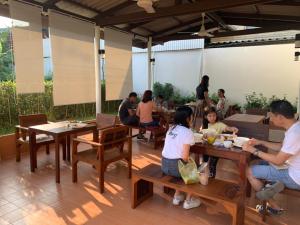 um grupo de pessoas sentadas em mesas em um restaurante em Baan Suan Krung Kao em Phra Nakhon Si Ayutthaya