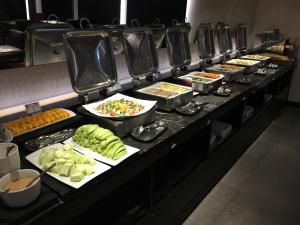 una línea de buffet con muchos platos de comida en Tango Motel, en Taipéi