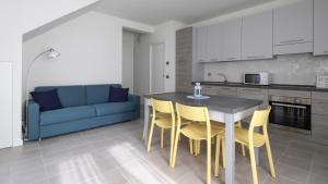 una cucina con tavolo, sedie e divano blu di Italianway - Giuseppe Pastine 17/D a Santa Margherita Ligure
