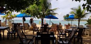 grupa stołów i krzeseł na plaży w obiekcie Sunset Colony Beach Resort w mieście Galle