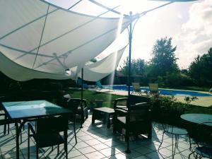 a patio with tables and chairs and an umbrella at La maison de Thiré in Thiré