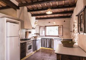 uma cozinha com um frigorífico branco e um balcão em Masia Mediterranian Country House Ca l'Isidre Torrent em Sant Cebrià de Vallalta