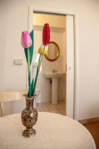 un jarrón con flores sobre una mesa en el baño en Le Violette, en Lucca