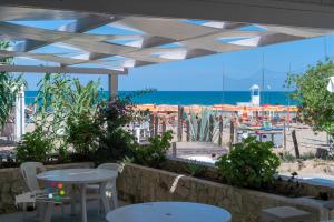 a patio with tables and chairs and a view of the beach at Villaggio Camping Punta Lunga in Vieste