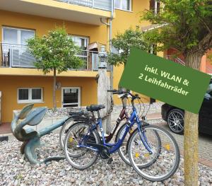 zwei Fahrräder, die neben einem Schild vor einem Gebäude geparkt sind in der Unterkunft Ferienresidenz zur Ostsee in Zempin