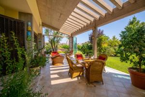 a patio with wicker chairs and a table at Villa Tigli Luxury B&B in Martinsicuro