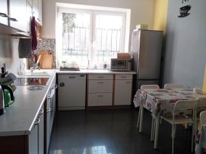 a kitchen with a table and a refrigerator at Mira Rent House in Warsaw