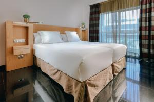 a hotel room with a large bed and a large window at Hesperia Fira in Hospitalet de Llobregat