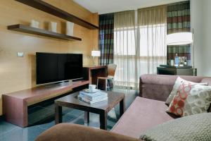 a living room with a couch and a television at Hesperia Fira in Hospitalet de Llobregat