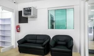 two black leather chairs in a room with a tv at Treebo Trend Luxe Suite Shivaji Nagar in Pune