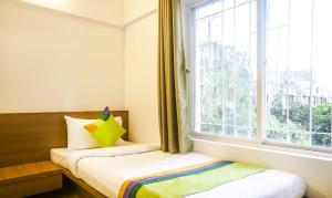 Postel nebo postele na pokoji v ubytování Treebo Luxe Suite, Shivaji Nagar