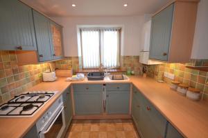 a kitchen with blue cabinets and a stove top oven at The Stables in Saint Helens