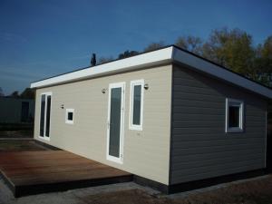 a tiny house with a wooden deck at Witven in Veldhoven