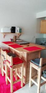 uma cozinha com uma mesa de madeira e algumas cadeiras em Le Galibier em La Salle Les Alpes