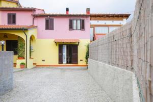 a yellow and pink house with a fence at Casa Giulia - HelloElba in Marina di Campo