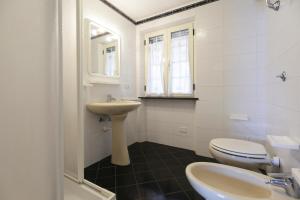 a white bathroom with a sink and a toilet at Casa Giulia - HelloElba in Marina di Campo