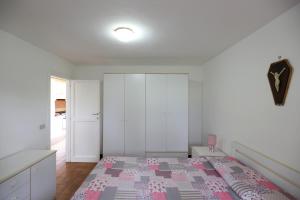 um quarto com uma cama com um cobertor rosa e cinzento em Casa Giulia by HelloElba em Marina di Campo