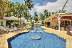 einen Pool mit Liegestühlen und ein Resort in der Unterkunft Cocotiers Hotel – Mauritius in Port Louis