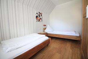 two beds in a room with white walls and wooden floors at Ferienwohnungen Georg Andre Söhne in Ernst