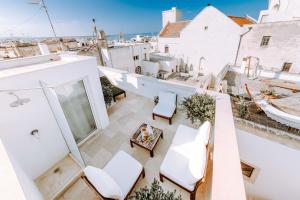 a balcony with white chairs and a table at Dimora Anderì in Polignano a Mare