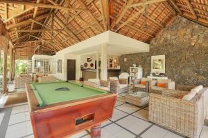 a living room with a pool table in a house at Cocotiers Hotel – Mauritius in Port Louis