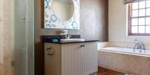 une salle de bain avec un lavabo, une baignoire et un miroir dans l'établissement Navarre Farm Cottages, à Stellenbosch 40 autres photos