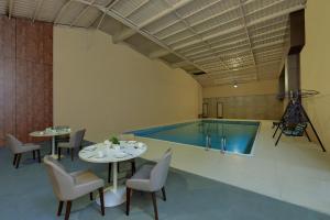 a pool with tables and chairs and a swimming pool at The Fern Residency Aurangabad in Aurangabad