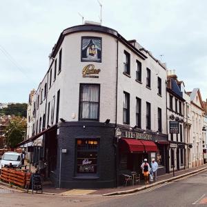 a building on a street with people standing in front of it at Town House Rooms in Hastings