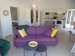 Villa More في بوتشيتشا: غرفة معيشة مع أريكة أرجوانية ووعاء من الفواكه
