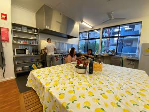 um grupo de pessoas em uma cozinha com uma mesa em Downtown Backpackers Hostel Perth - note - Valid Passport required for check in em Perth