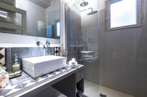 雅典的住宿－Hidesign Athens Luxury Apartments in Kolonaki，浴室配有白色水槽和淋浴。