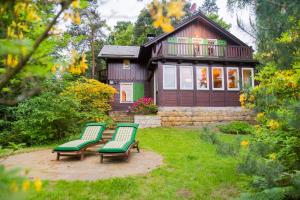 due panche verdi di fronte a una casa di Haus Schrammsteinblick a Ostrau