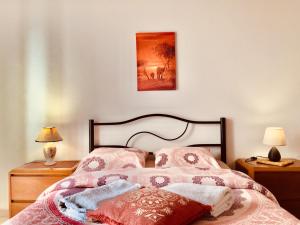 アングラ・ド・エロイーズモにあるVilla Atlantica Apartmentsのベッドルーム1室(ピンクのシーツと絵画付)