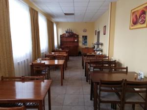 uma sala de jantar com mesas e cadeiras de madeira em Hotel Salem em Aktau