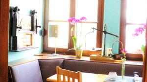 eine Küche mit einem Tisch und ein paar Blumen an den Fenstern in der Unterkunft Hotel Dalberg in Sankt Martin