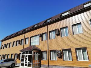 a wooden building with a car parked in front of it at Hotel Salem in Aktau