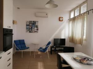 ein Wohnzimmer mit blauen Stühlen und einem Tisch in der Unterkunft La casa di Alice in Patù