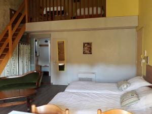 1 dormitorio con 2 camas y escalera en La SERPAUDERIE en Saint-André-de-Lidon