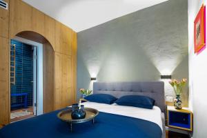 a bedroom with a large bed with blue pillows at Boutique & Comfort in David's Village by FeelHome in Jerusalem