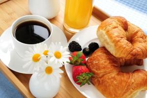 a plate of pastries and a cup of coffee and strawberries at Hotel Sirios in San Giovanni Rotondo