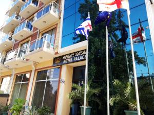 un edificio con bandiere di fronte di Hotel Royal Palace a Batumi