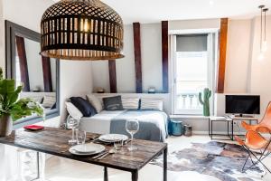 ein Wohnzimmer mit einem Bett und einem Tisch mit Weingläsern in der Unterkunft El Alma de las Ramblas in Barcelona