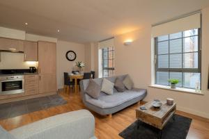 een woonkamer met een bank en een tafel bij Stylish & Cosy Apartment in Nottingham