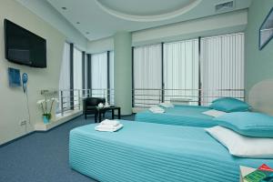 a bedroom with two beds and a flat screen tv at Air Express INSIDE Sheremetyevo FREE ZONE in Khimki