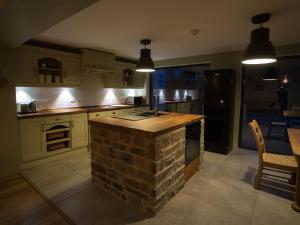 a kitchen with a brick island in the middle at Chapel House Cottage in Builth Wells